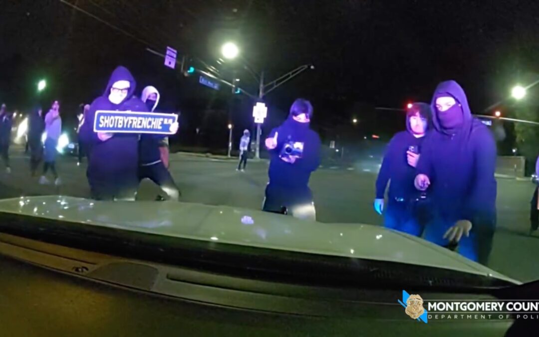 Masked mob attacks police cruiser with officer inside during illegal street takeover